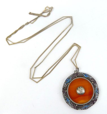 Lot 2585 - A white metal circular pendant, with banded...