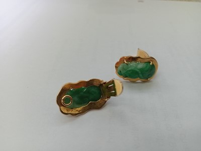 Lot 2586 - A yellow metal carved jadeite pendant and...