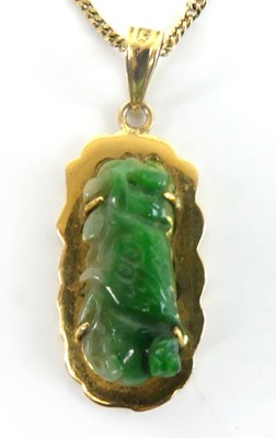 Lot 2586 - A yellow metal carved jadeite pendant and...