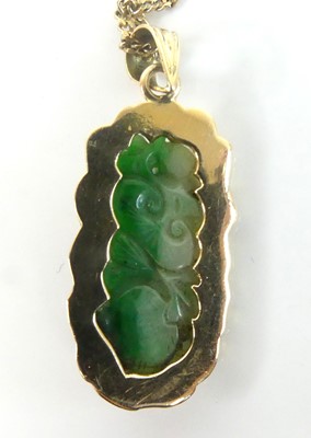 Lot 2586 - A yellow metal carved jadeite pendant and...
