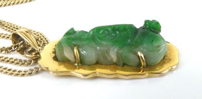 Lot 2586 - A yellow metal carved jadeite pendant and...