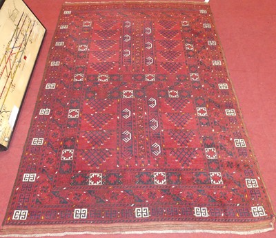 Lot 1160 - A Persian wollen red ground Bokhara rug, with...