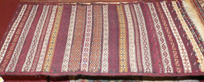 Lot 1176 - A Turkish woollen red ground Kelim hall rug,...