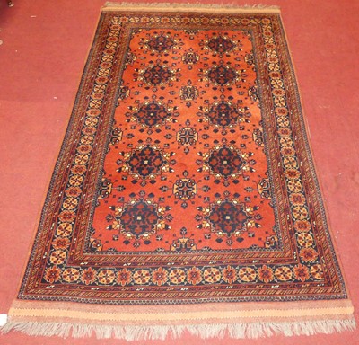 Lot 1180 - A Persian woollen red ground Bokhara rug,...