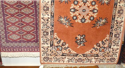 Lot 1182 - A Persian style machine woven red ground rug,...