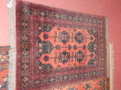 Lot 1183 - A Persian woollen red ground Bokhara rug, with...