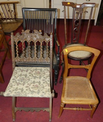 Lot 1339 - A circa 1900 ebonised slatback low elbow chair;...