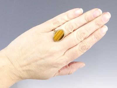 Lot 2547 - A 9ct gold tiger's eye set dress ring, the...