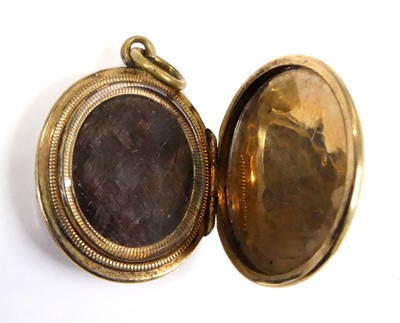 Lot 2551 - A yellow metal oval picture locket, having...