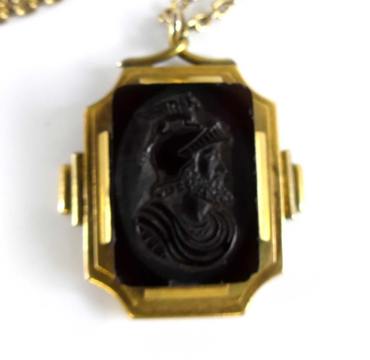 Lot 2735 - A carved carnelian pendant as a profile...