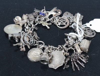 Lot 393 - A modern silver curblink bracelet, containing...