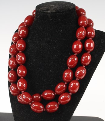 Lot 406 - A faux cherry amber necklace arranged as 40...