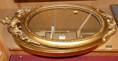 Lot 1098 - A gilt composition framed bevelled oval wall...