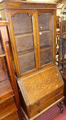 Lot 1438 - A 1920s moulded oak bureau bookcase, having...