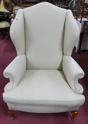 Lot 1331 - A cream floral fabric upholstered wingback...