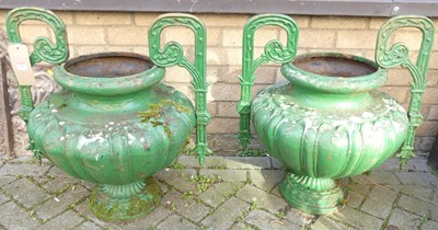 Lot 1409 - A pair of cast iron twin handled garden urns,...