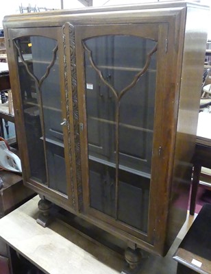 Lot 1371 - A 1930s oak double door glazed bookcase, w.92.5cm