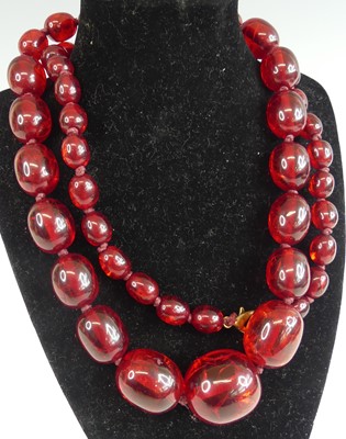 Lot 363 - A beaded and knotted simulated cherry amber...