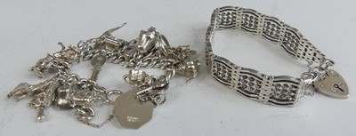 Lot 482 - A modern silver curblink bracelet, containing...