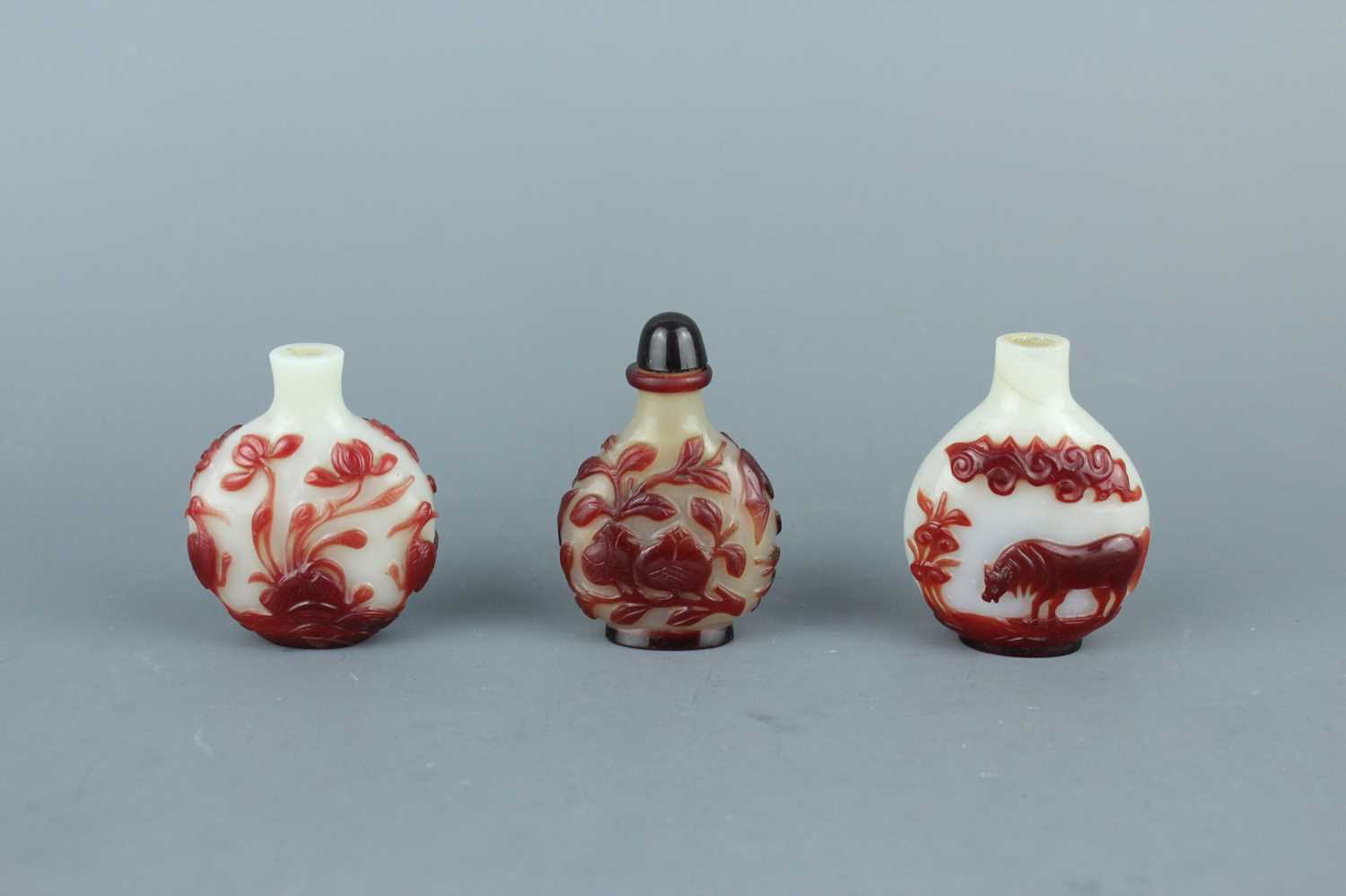 Lot 2019 - A set of three Chinese red overlay white glass...