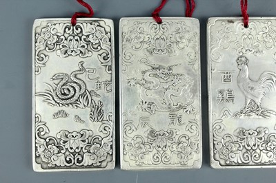 Lot 2058 - Seven Chinese white metal zodiac plaques...