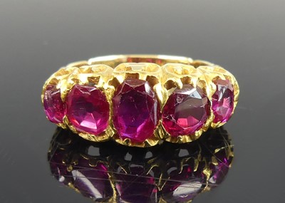 Lot 2642 - A yellow metal ruby half eternity ring,...