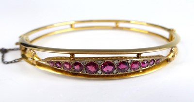 Lot 2684 - A 9ct yellow gold hinged oval openwork bangle,...