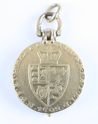 Lot 2431 - A yellow metal coin locket, the dual hinged...