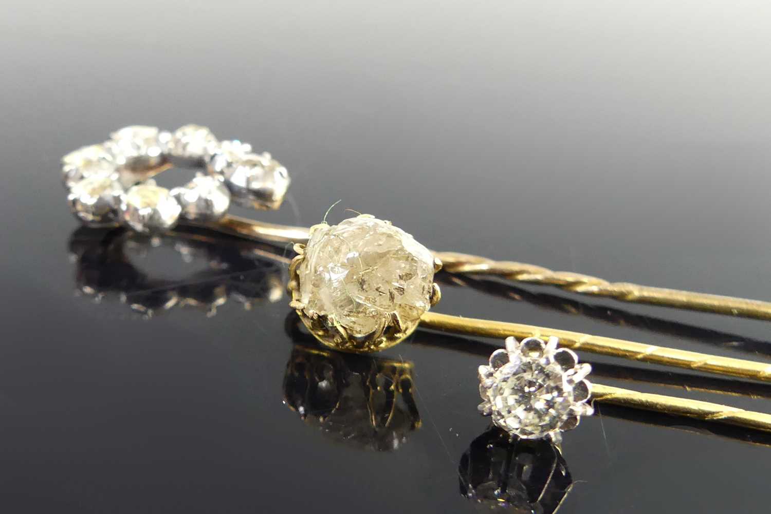 Lot 2818 - Three yellow metal diamond stick pins, one...