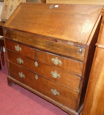 Lot 1393 - A George III provincial oak slopefront writing...