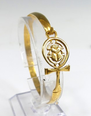 Lot 2297 - A yellow metal Egyptian circular bangle with a...