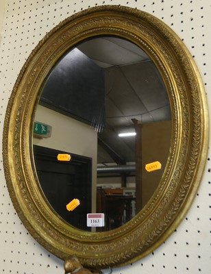 Lot 1163 - A floral decorated giltwood oval wall mirror,...