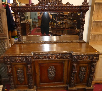 Lot 1192 - A circa 1900 heavily carved oak mirrorback...