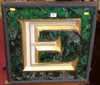 Lot 1042 - A glazed letter E, with gilded outline on faux...
