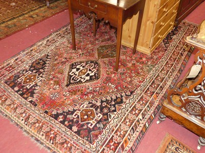 Lot 1445 - A Persian woollen Shiraz rug, the red ground...