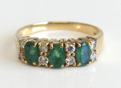 Lot 2258 - A yellow metal, emerald and diamond half...