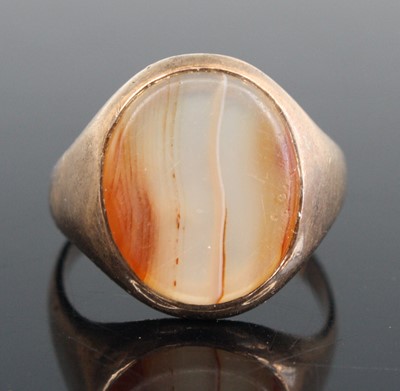Lot 266 - A yellow metal banded agate set signet ring,...