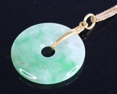 Lot 285 - A polished celadon jade disc pendant, dia....