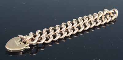 Lot 289 - A 9ct gold curb link bracelet with heart...