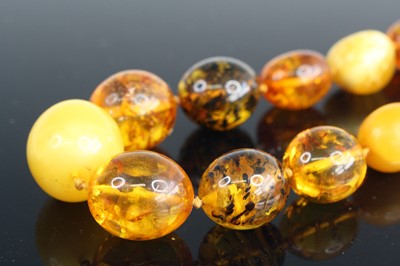 Lot 314 - A beaded amber necklace, to include...