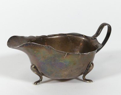 Lot 203 - A George V silver sauce boat, of helmet shape,...