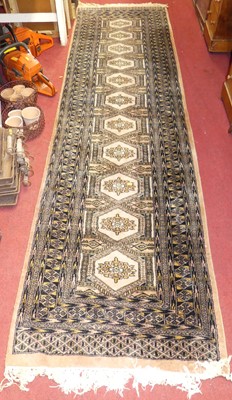 Lot 1120 - A Persian woollen peach ground Bokhara hall...