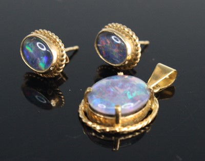 Lot 321 - A cabochon opal set in a yellow metal rope...