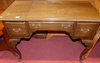 Lot 1189 - A walnut kneehole three drawer dressing table,...