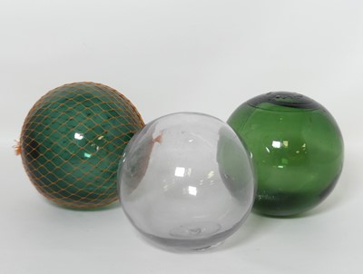 Lot 389 - A near pair of moulded green glass spheres,...