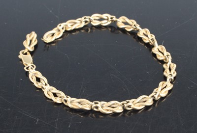 Lot 334 - A 9ct yellow gold fancy knot link bracelet...