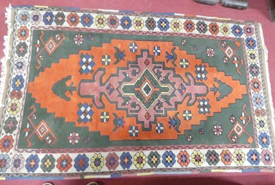 Lot 1164 - An Afghan woollen rug, the central green...