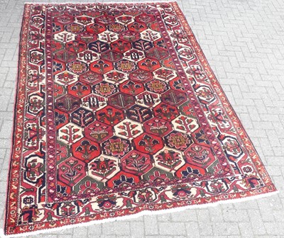 Lot 1201 - A Persian woollen red and blue ground...