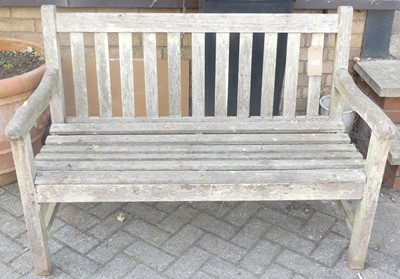 Lot 1381 - A contemporary slatted teak two-seater garden...