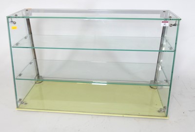Lot 83 - A glazed counter top display cabinet, having a...